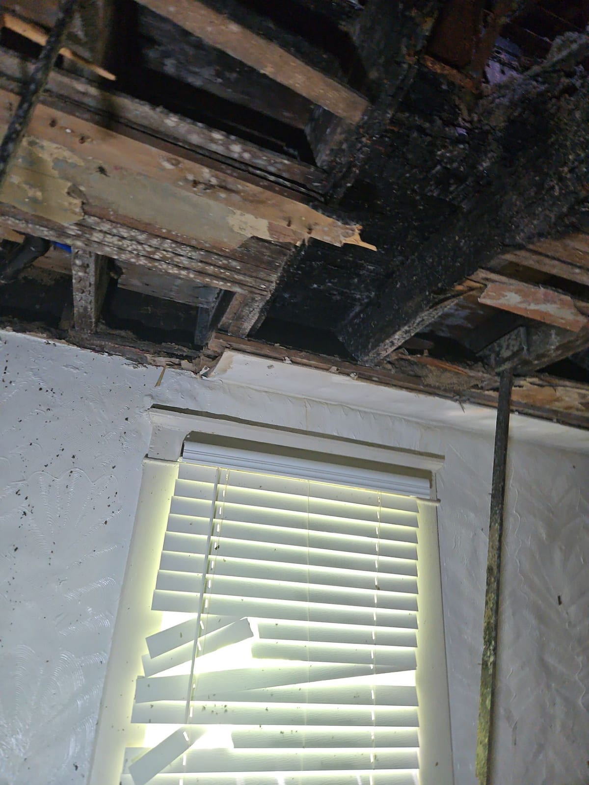 Burn-through in the ceiling above a bedroom window.