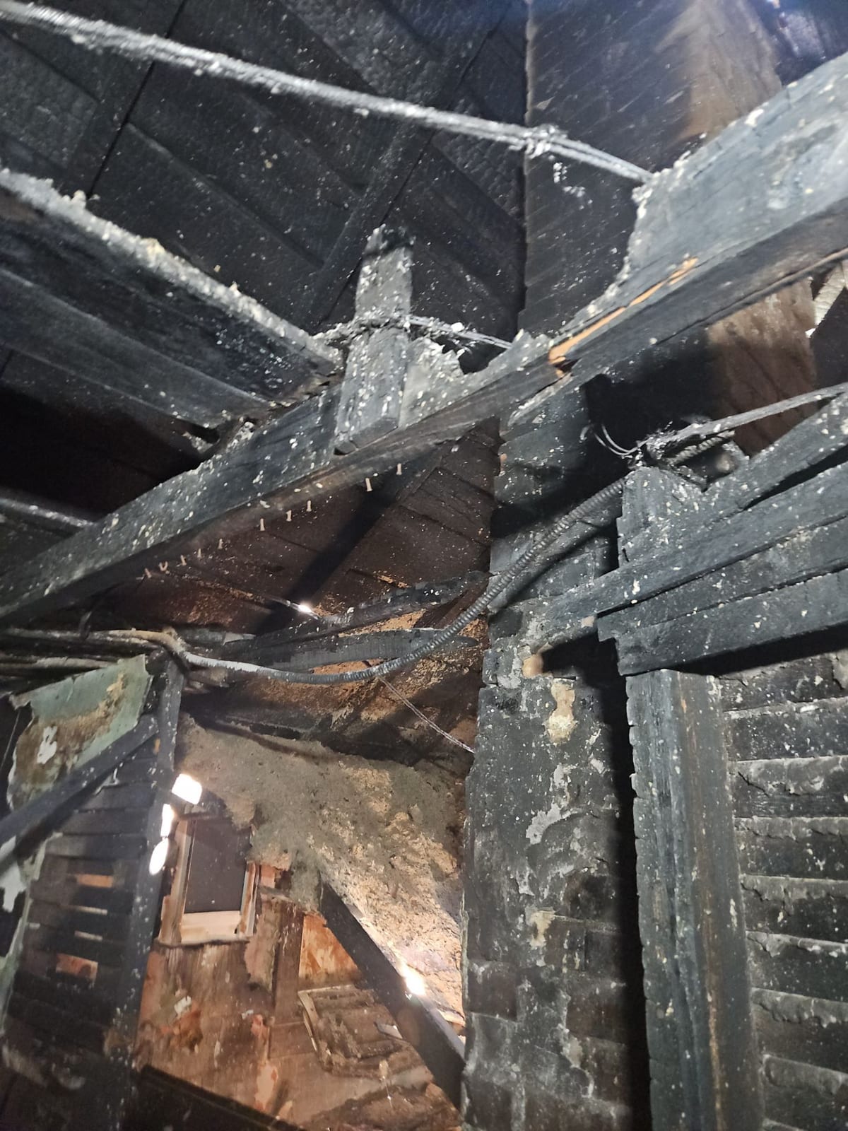 Fire-weakened roof rafters, partially collapsed.