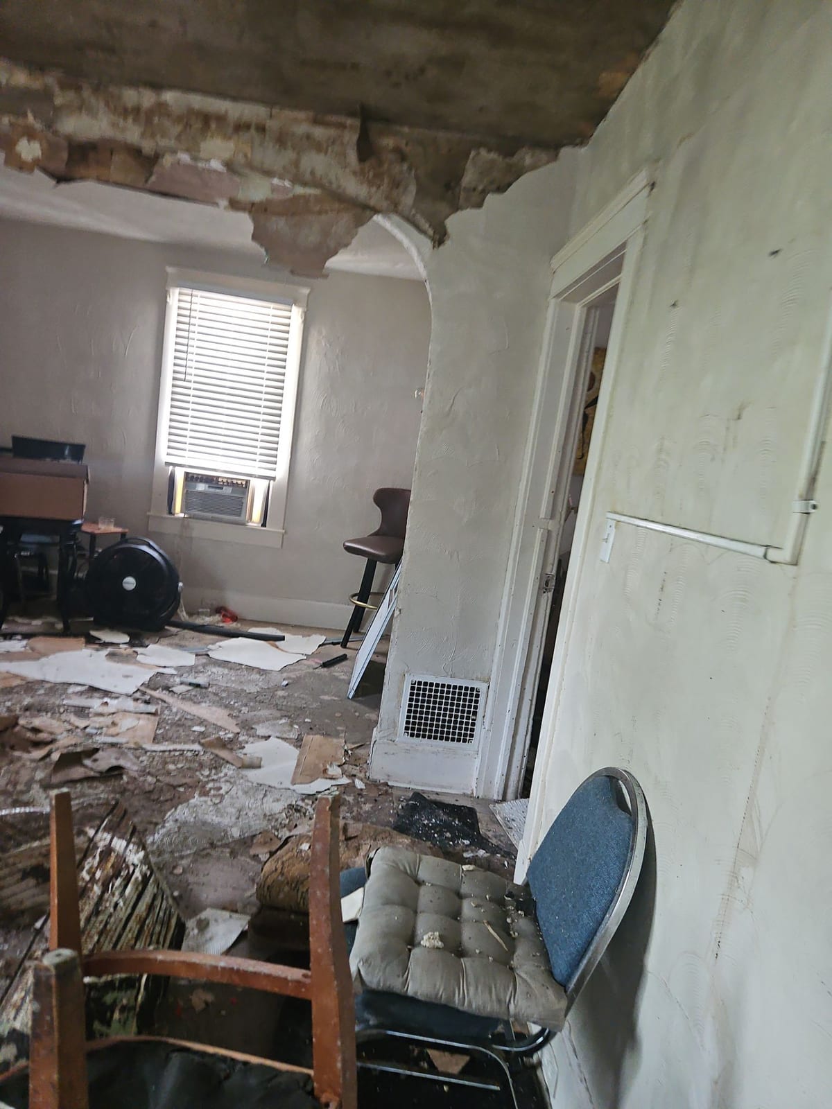 Smoke and water damage throughout the living space — documented mid-remediation, including the dehumidifier drying the structure.