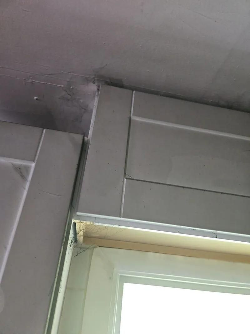 Soot staining darkens the ceiling and corner above the cabinets.