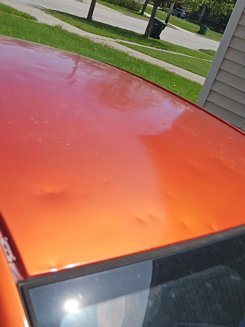 Hail dimples across a vehicle at the property — physical evidence of the same storm that struck the home.