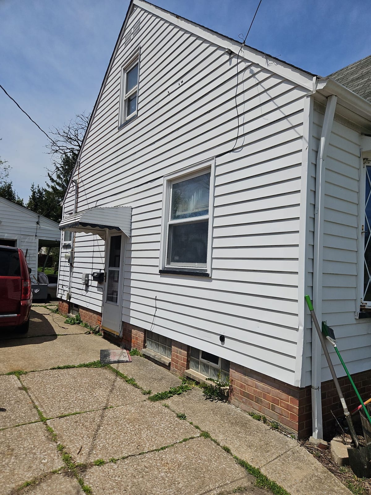 Hail-damaged white siding on a home in Bedford, Ohio