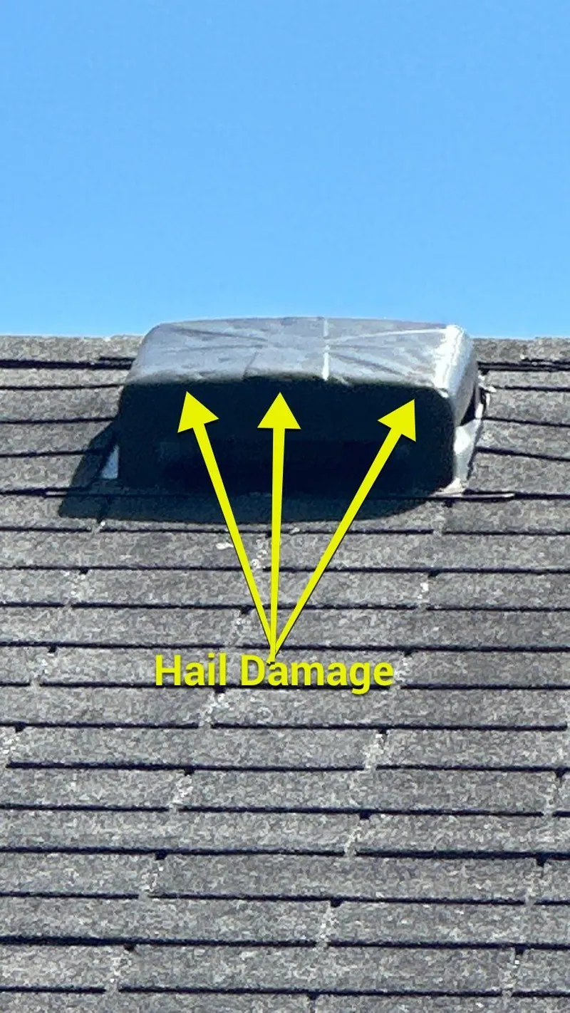 A hail-struck roof vent, dented across the cap — one of several roof accessories hit.