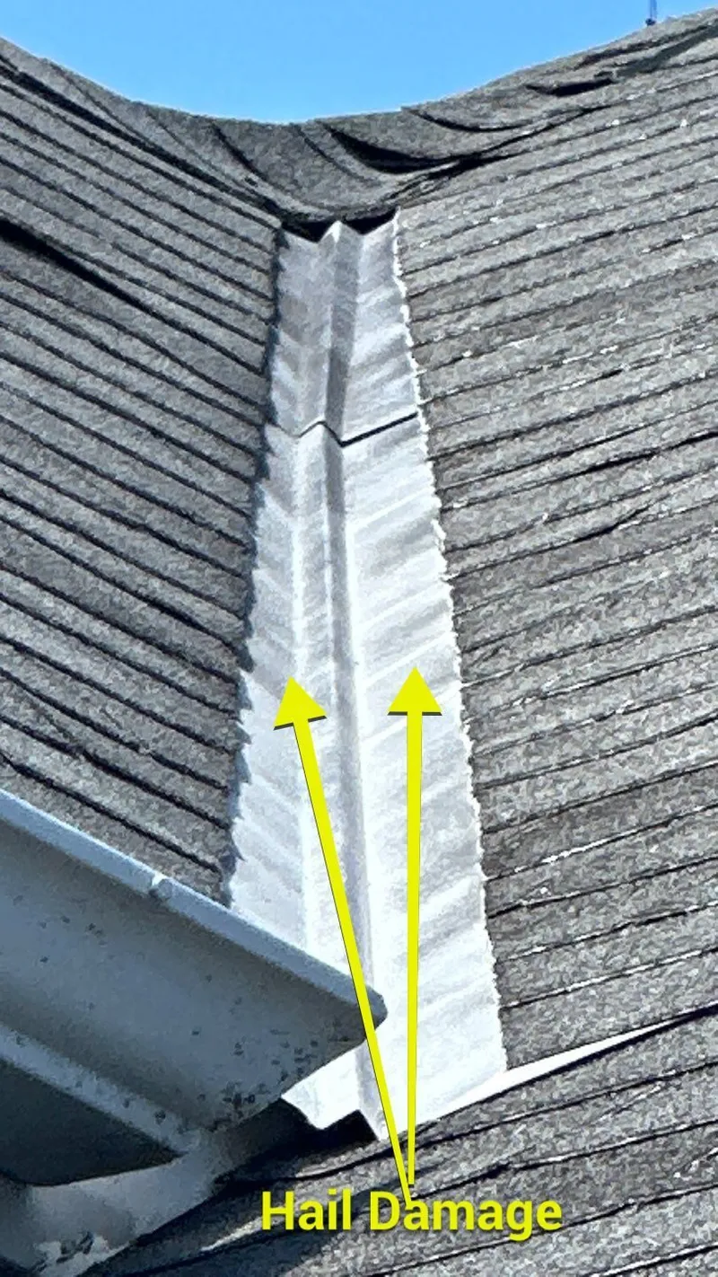 Hail damage marked on the roof valley metal — soft metals take a clear, measurable dent that proves a real hail event.
