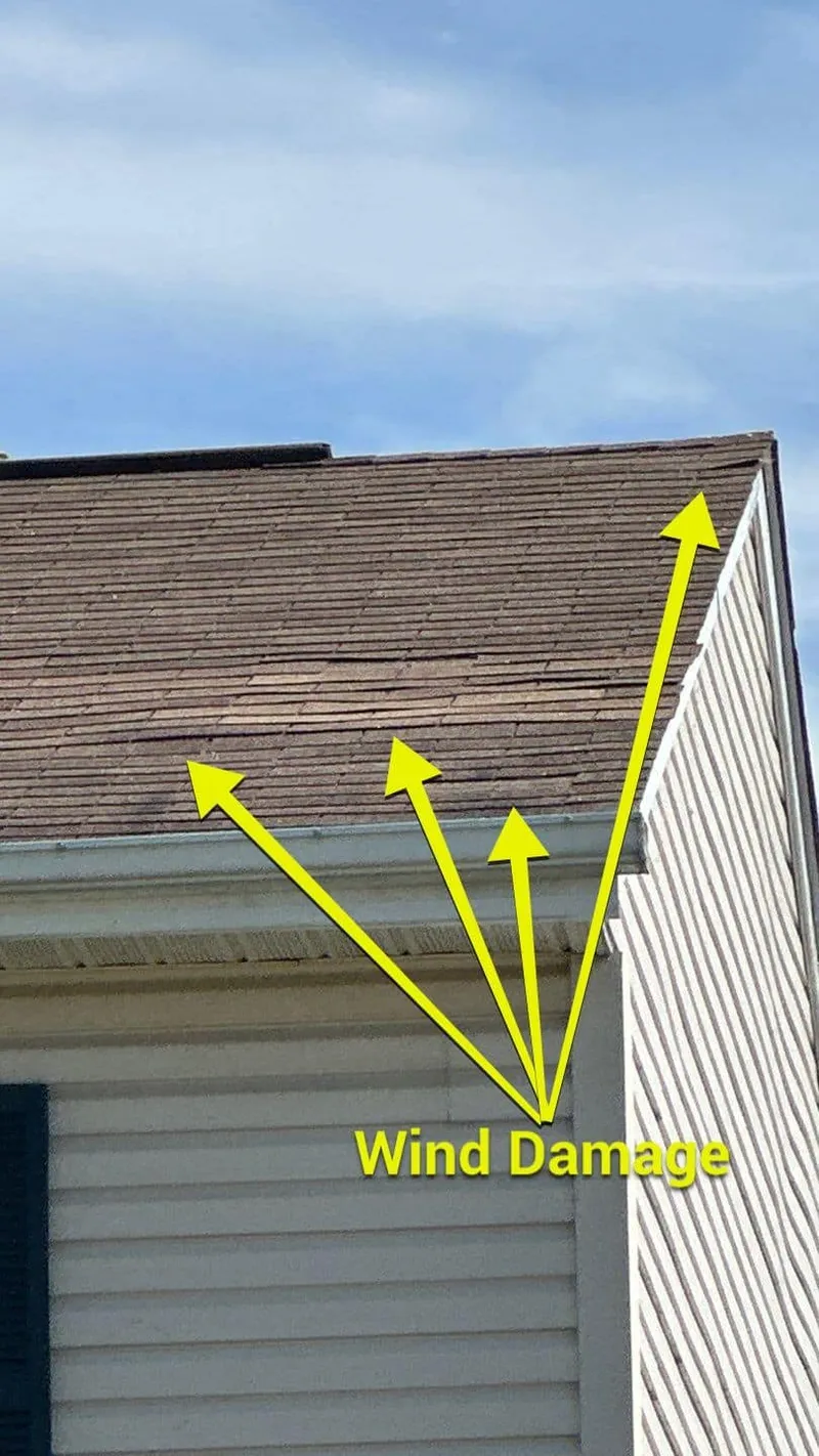 Wind damage marked from the ground — the arrows show the affected roof planes.