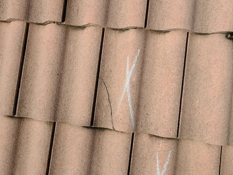 Up close: a split tile that no longer sheds water. Matching discontinued tile often forces a full replacement.