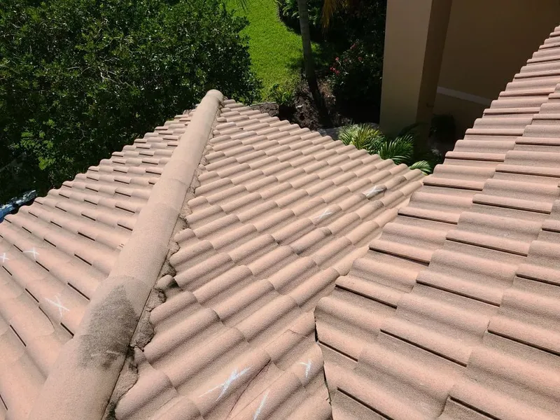 Damage carries over the hips and ridges onto multiple planes — the signature of a storm loss, not foot traffic.