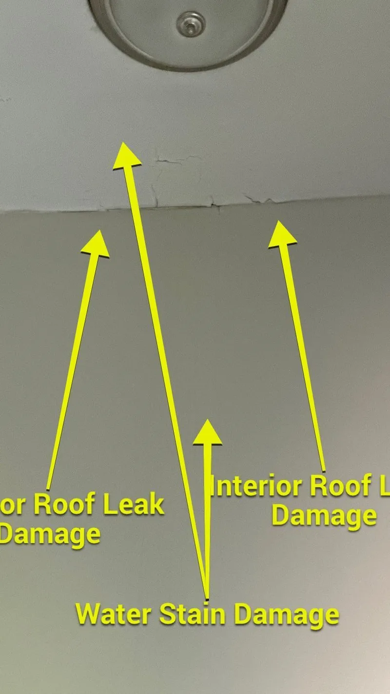 Roof-leak damage at a ceiling-and-wall corner, with the paint already lifting from the moisture.