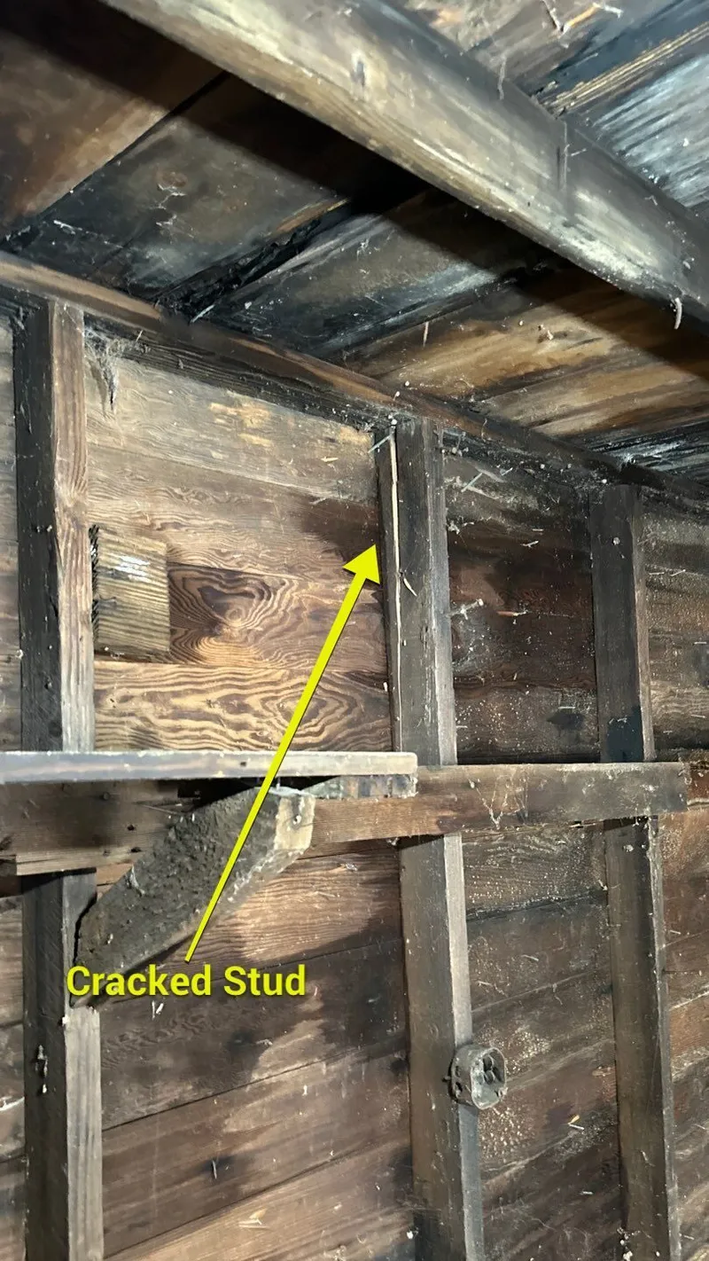 Inside the garage: a cracked wall stud where the impact racked the structure — framing damage the carrier's estimate skips.