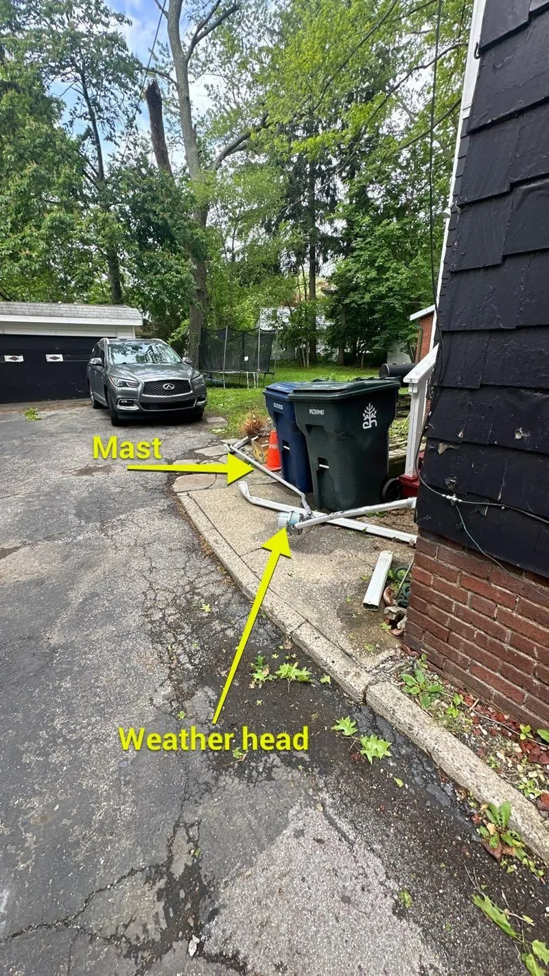 On the house, the wind tore the electrical service mast and weather-head clean off — left lying in the yard.
