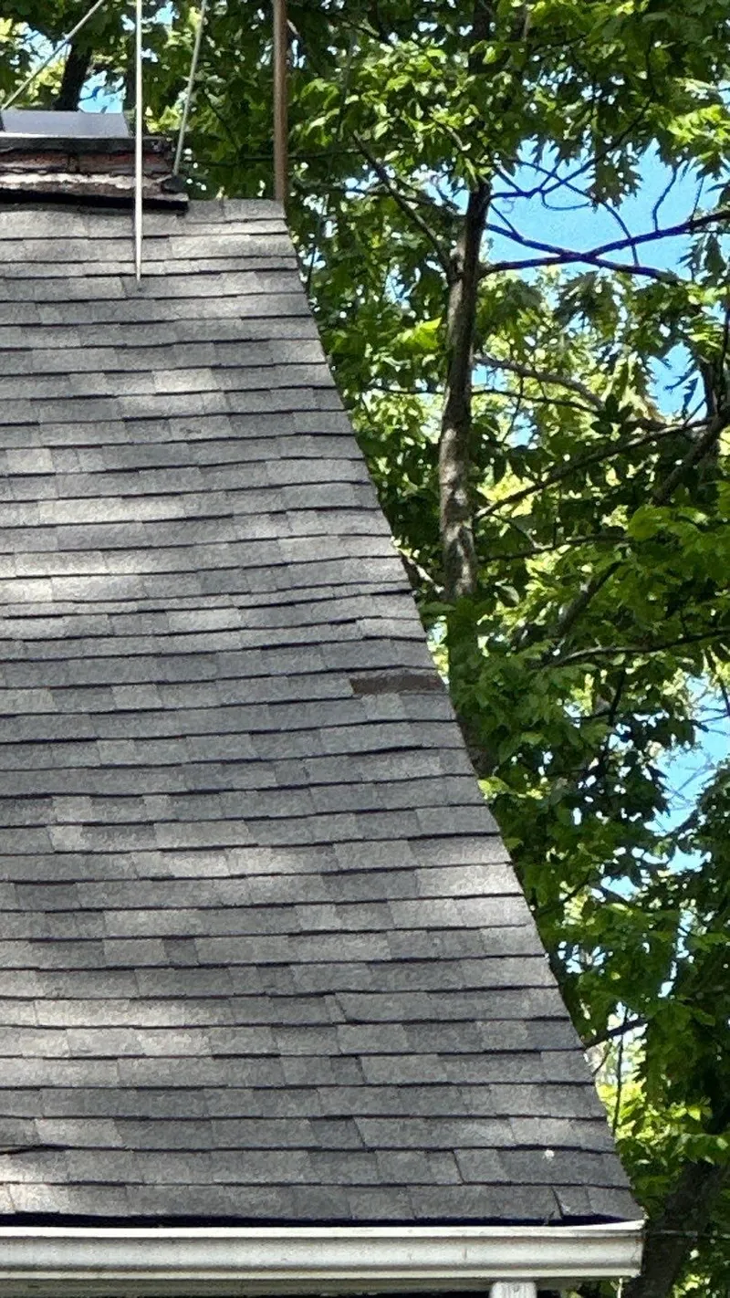 Lifted and creased shingles on the main roof — the same storm, documented slope by slope.