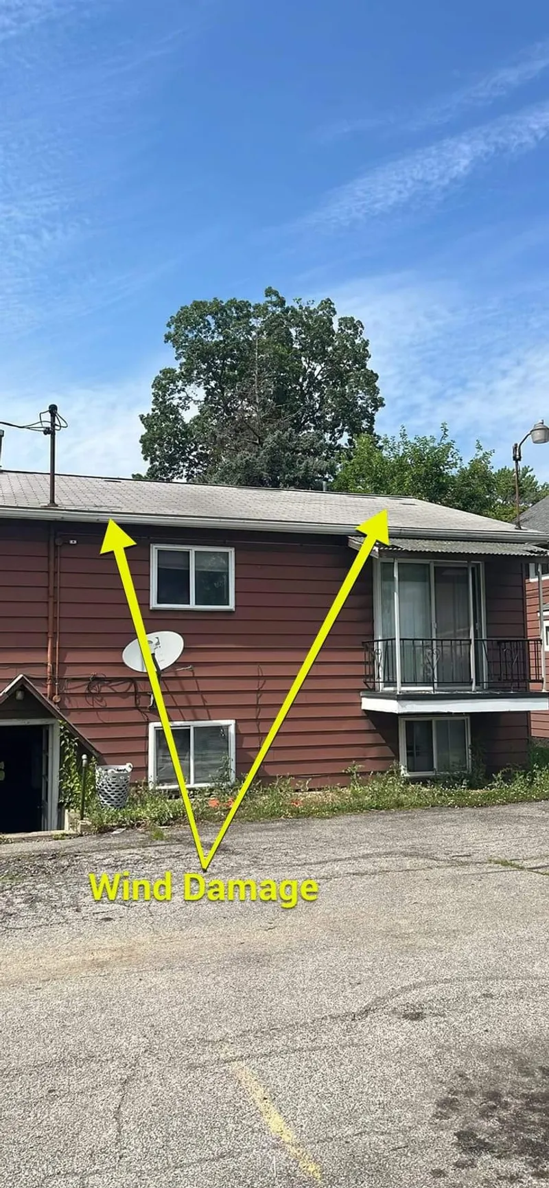 Wind damage marked on the roof — the arrows point to where high winds lifted and creased the shingles.